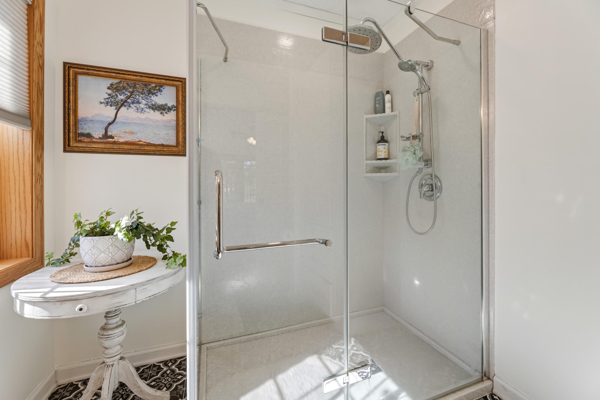 Sleek glass-enclosed shower adds a fresh, modern touch to the primary suite.