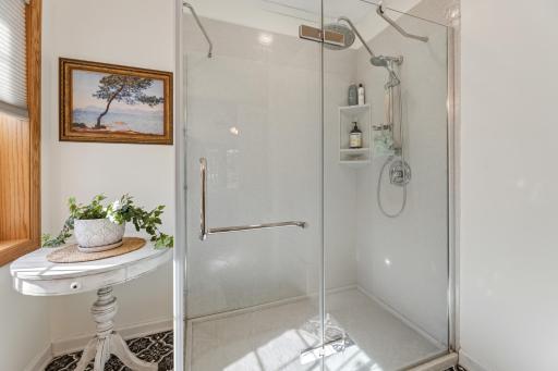 Sleek glass-enclosed shower adds a fresh, modern touch to the primary suite.