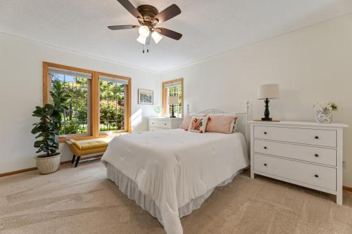 This space offers plush carpeting, neutral tones, and a ceiling fan for added comfort.