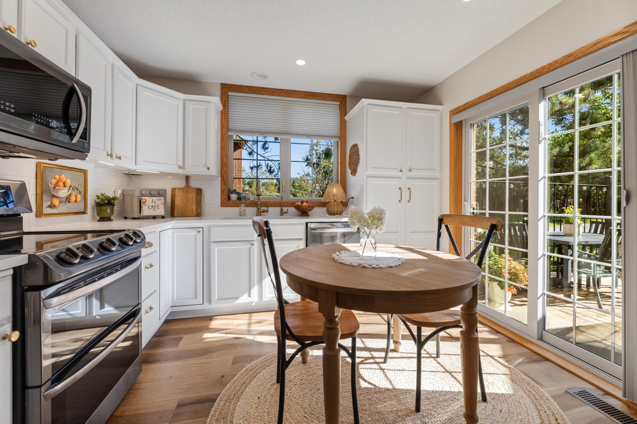 Bright eat-in kitchen features crisp white cabinetry and updated countertops.