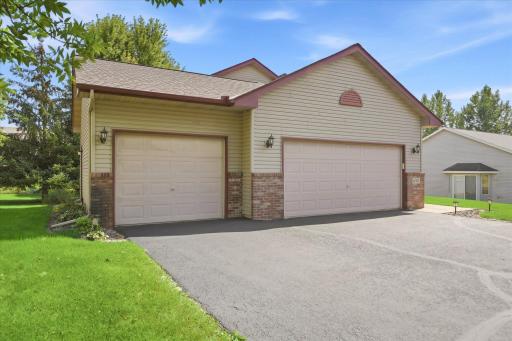 Spacious three-car garage and freshly sealed driveway provide plenty of room for vehicles, storage, and additional parking.