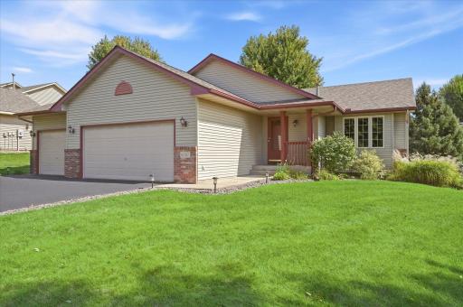 Welcoming front exterior featuring attractive landscaping, low-maintenance vinyl siding, gutters, and a covered front entry.