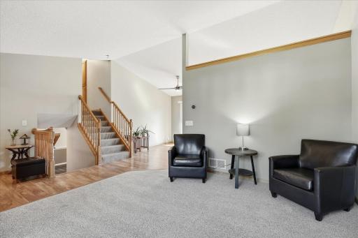 Bright living room with new carpet and large windows, conveniently positioned just off the foyer with easy access to the upper and lower levels.