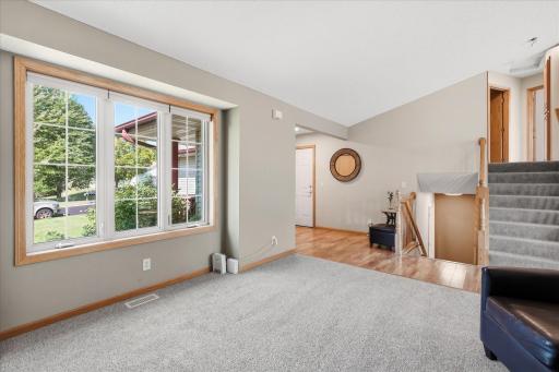 Vaulted living room offers generous space for a variety of furniture arrangements, along with new carpet and abundant natural light.