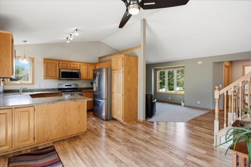 Open kitchen flows seamlessly into the main living areas, showcasing the vaulted layout, abundant cabinetry, stainless steel appliances, and generous counter space.