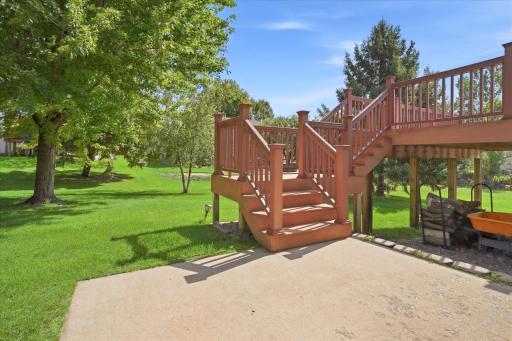 Lower-level walkout opens directly to a concrete patio, providing another convenient outdoor living space beneath the deck.