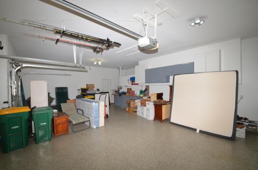 Finished 3 car garage with insulated garage doors, epoxy floors, a built in workbench and an abundance of cabinets. Wifi enabled garage door opener and new wifi sprinkler controls cabinets. Service door that leads to side yard.
