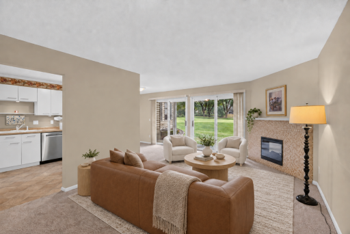 Bright and inviting living room with new carpet and an electric fireplace. Digitally Staged.