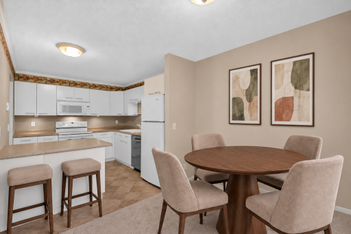 Light-filled dining space with easy access to the kitchen. Digitally Staged