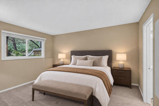 Spacious primary bedroom with new carpet and walk-in closet. Digitally Staged