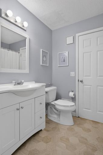 Updated walk-through full bathroom with new flooring and convenient access from the primary bedroom.