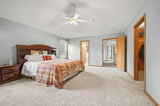 View of the primary bath, hallway to the other bedrooms and walk-in closet to the right.