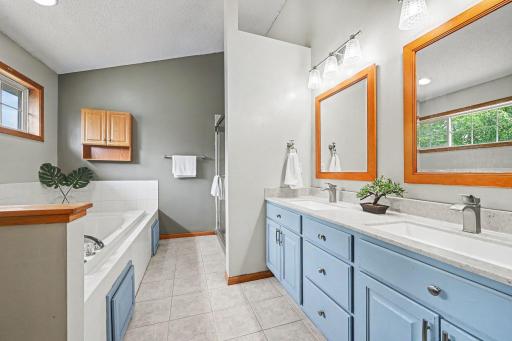 Recent remodeled primary bath with double sink, tile flooring, large tub,