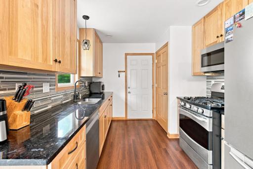 Granite counters, newer cabinets, tile backsplash, Stainless Steel appliances, and a gas range.