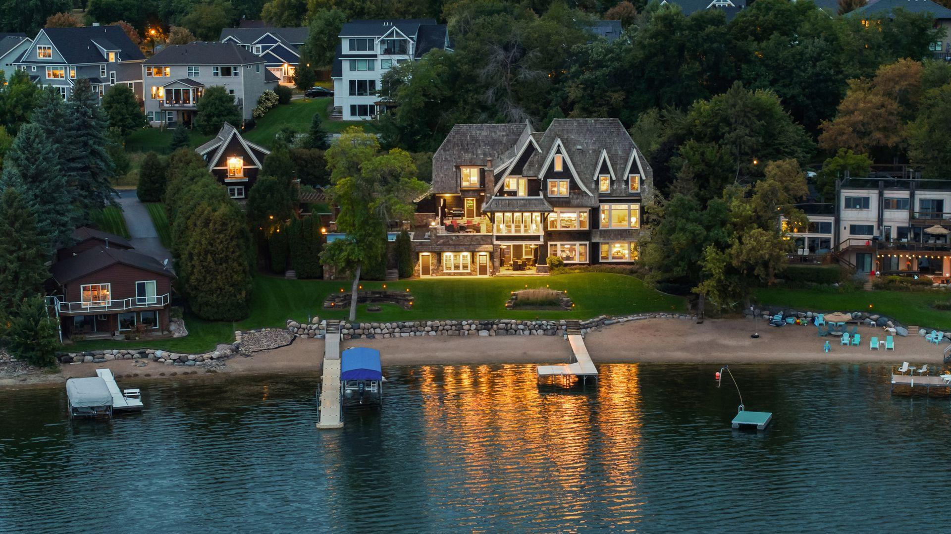 Lakefront exterior with private beach and docks at dusk