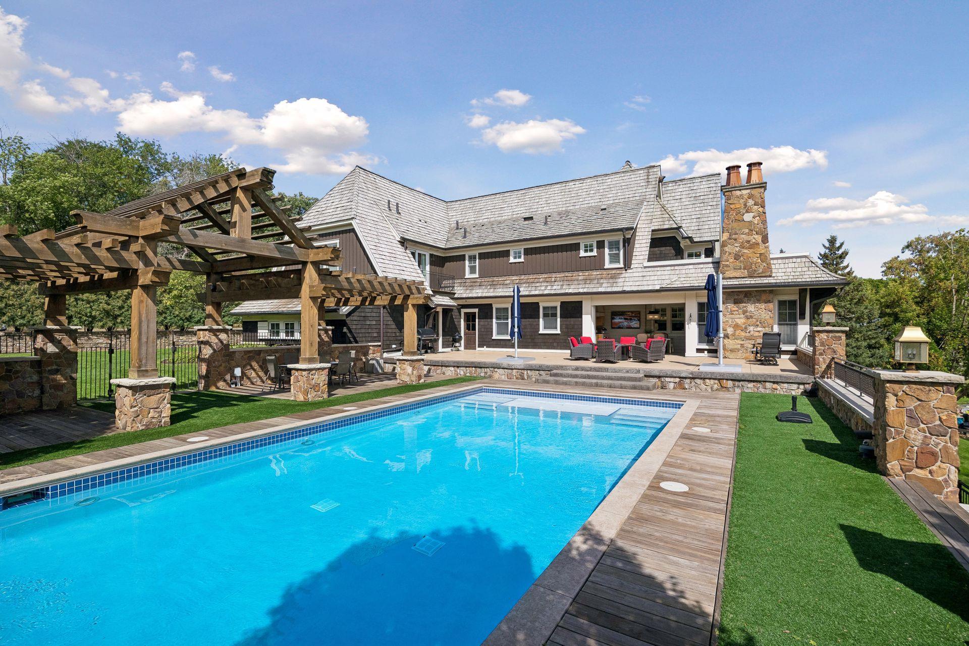 Outdoor pool/pergola/fireplace area in daylight