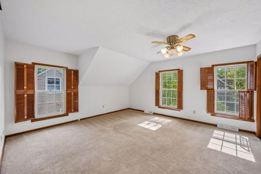 Upstairs primary bedroom is full of windows and light
