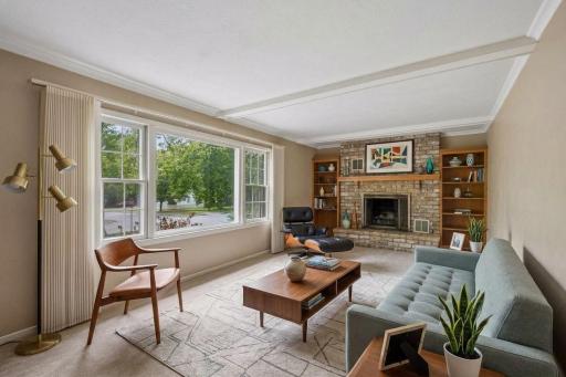 Living room includes large window and fireplace - virtually staged