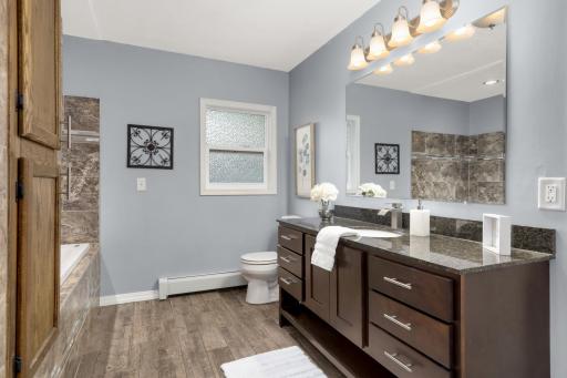 Tile surrounds, granite countertop and an updated vanity give this Bath a finished look.