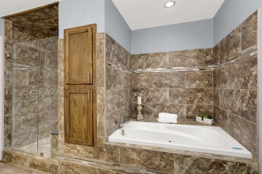 Updated full Bath features a Jacuzzi tub with tile surround and a separate tiled shower.