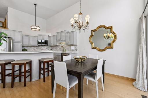 Wood flooring carries from the kitchen into the dining area, creating a natural flow between the two spaces and giving the open main level a warm, cohesive feel.