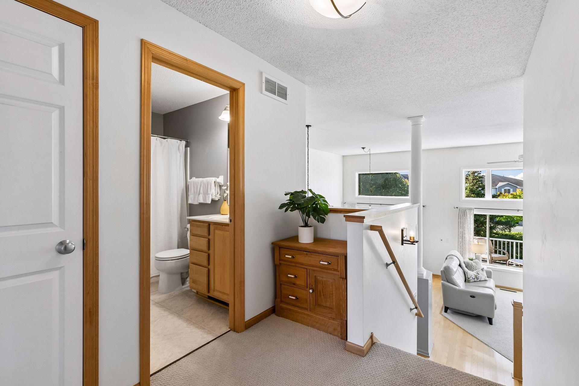 The open upper landing creates a natural transition between the bedrooms while keeping the dramatic two-story living space connected to the upper level.