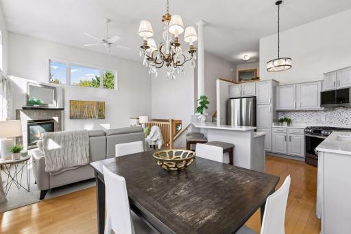 The dining room connects the kitchen and living areas while maintaining its own defined space, with wood floors and abundant natural light adding to its appeal.