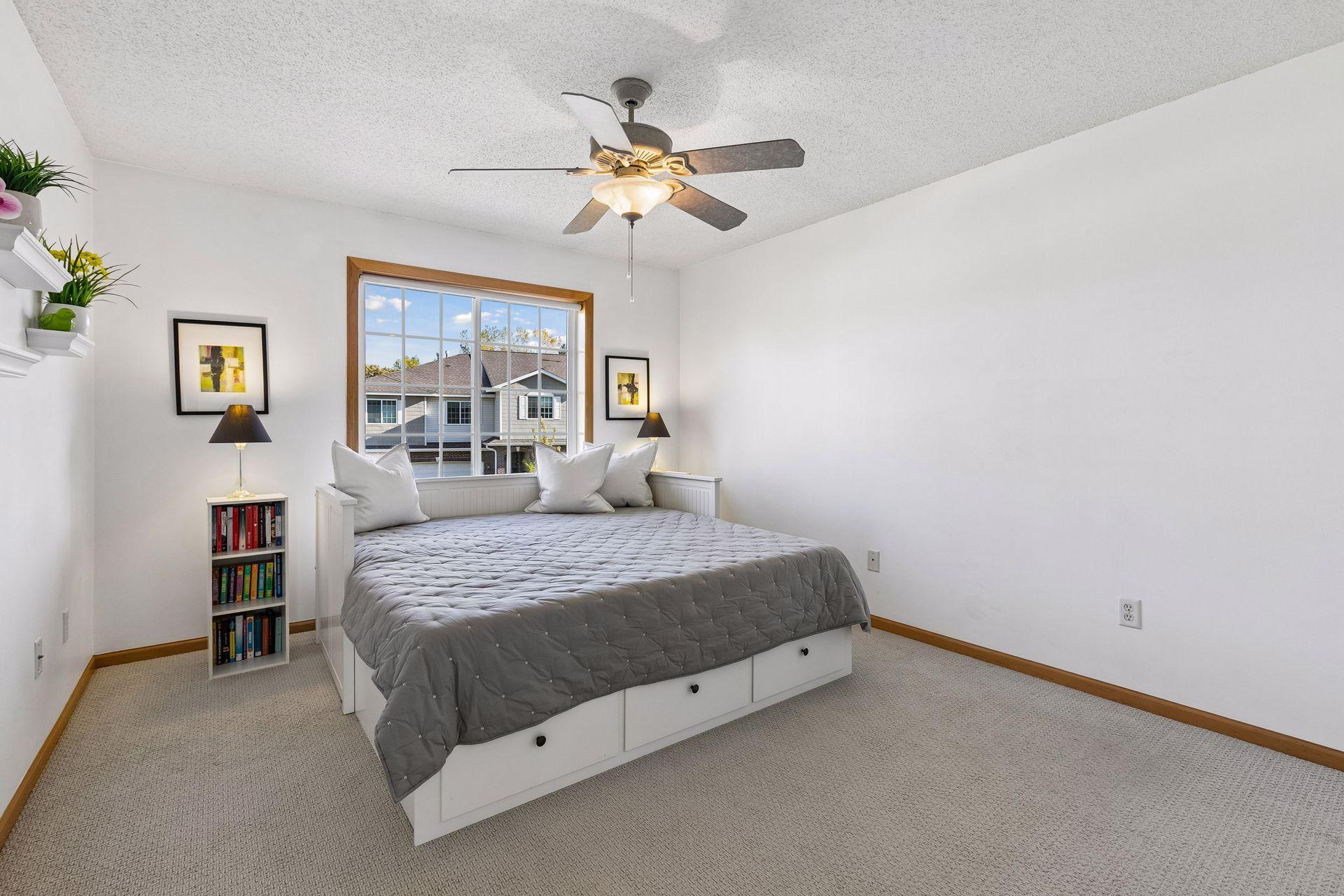 The second upper-level bedroom is surprisingly generous in size, with large windows bringing plenty of natural light into the space while a full bath just steps away adds everyday convenience.