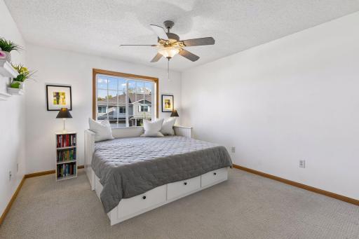 The second upper-level bedroom is surprisingly generous in size, with large windows bringing plenty of natural light into the space while a full bath just steps away adds everyday convenience.