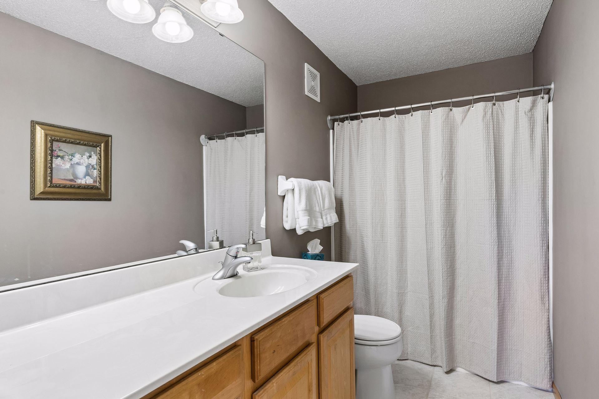 Modern finishes give the primary en-suite bath a fresh, polished look.