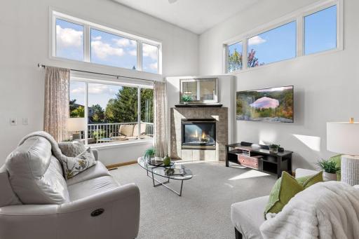 A gas fireplace anchors one side of the living room, topped by transom windows that bring even more light into the vaulted space.