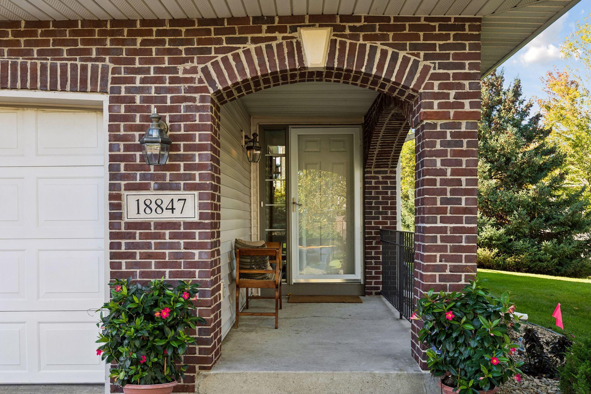 A welcoming first impression starts with a covered front porch framed by a distinctive brick archway, with leafy views of the lush side yard adding to the appeal of this end unit townhome.