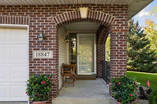 A welcoming first impression starts with a covered front porch framed by a distinctive brick archway, with leafy views of the lush side yard adding to the appeal of this end unit townhome.