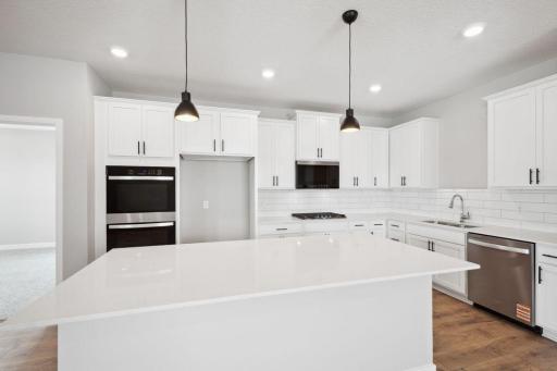 Stainless steel appliances, quartz counter tops and subway tile backsplash make this kitchen the center piece of the home. *Picture is of a model home. Actual finishes may vary.
