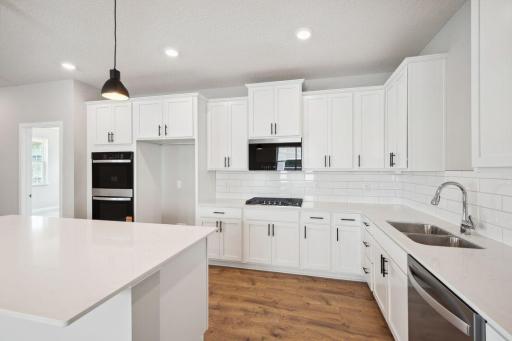 Stainless steel appliances, quartz counter tops and subway tile backsplash make this kitchen the center piece of the home. *Picture is of a model home. Actual finishes may vary.