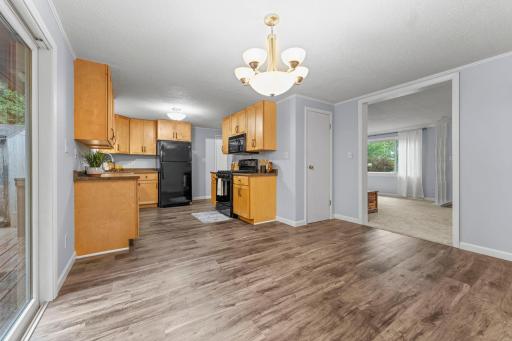 The kitchen flows seamlessly into the dining area, highlighted by a classic chandelier and direct access to the spacious backyard deck.