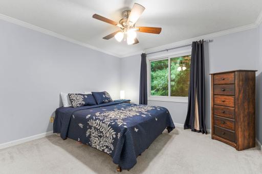 The main level features three bedrooms, including a comfortable primary suite with carpeting, ceiling fan, ample closet space, and access to a walk-through full bathroom.