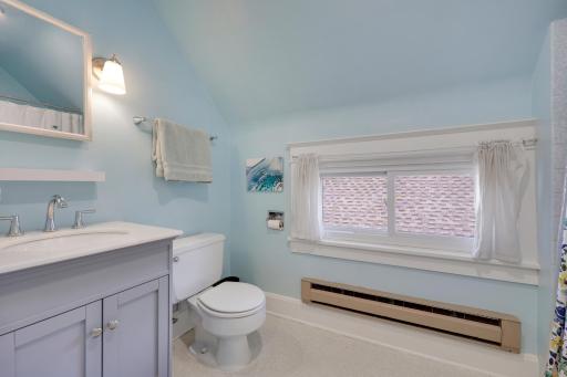 The upper-level bathroom is bright and updated with a large window and sleek vanity.