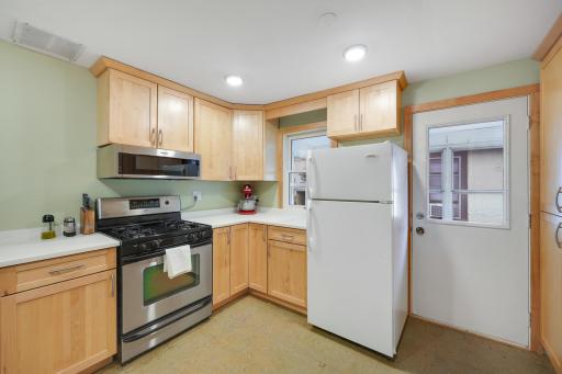 Warm wood cabinetry offers generous storage, while recessed lighting keeps the kitchen bright and inviting.
