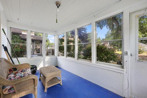 Walls of windows fill the porch with sunshine and offer a welcoming place to enjoy the changing seasons.