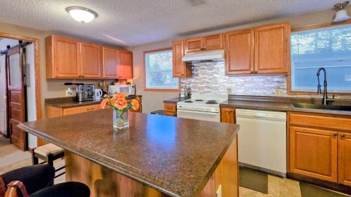 Spacious kitchen with a large island table, perfect for entertaining and meals, complemented by beautiful lake views.