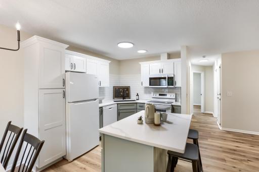 Kitchen with center island, ample cabinet space, and adjacent dining area with deck access.