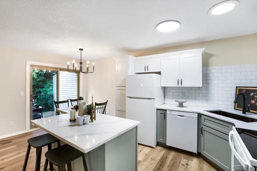 Updated kitchen with custom soft-close cabinetry, quartz countertops, and tile backsplash.