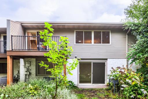 Patio and rear outdoor space overlooking mature trees and green space.