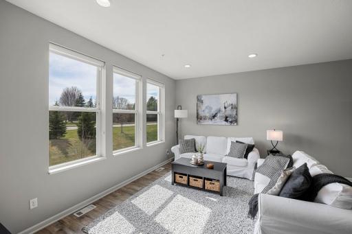 The bright living room features large windows that fill the space with abundant natural light.