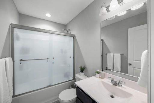 Both bedrooms are just steps away from a shared full bathroom with LVP flooring, a single vanity, and a tub/shower combination.
