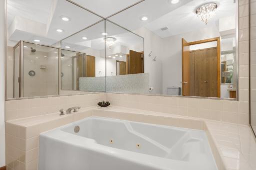 The jetted tub creates a spa like feeling with space surrounding the tub for decor accents and candles.
The mirror reflection shows the walk in shower located to the right of the tub.
