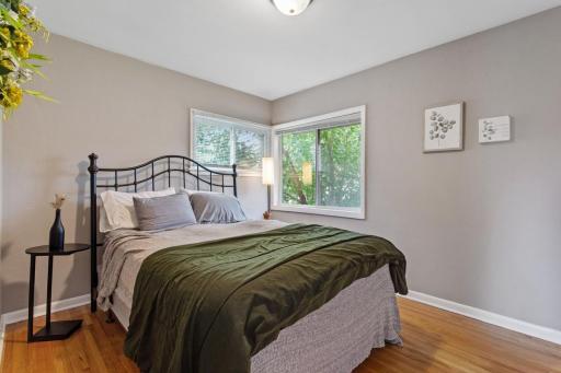 Spacious main-level bedroom with windows overlooking the beautiful backyard, fresh paint, and gleaming hardwood floors. White six-panel doors and trim throughout add a crisp, timeless finish.
