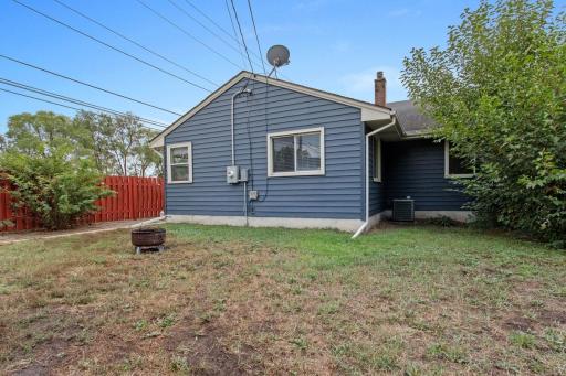 Beautiful rear view showcasing the maintenance-free metal siding, fully fenced backyard, and spacious corner lot. A private outdoor setting with plenty of room to relax, play, and enjoy. Convenient location near city bus and gold line!
