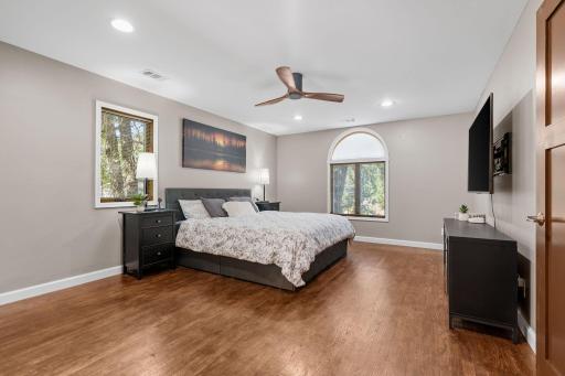 The spacious primary suite! Ceiling fan, hardwood floors, and features a walk in closet & private bath.